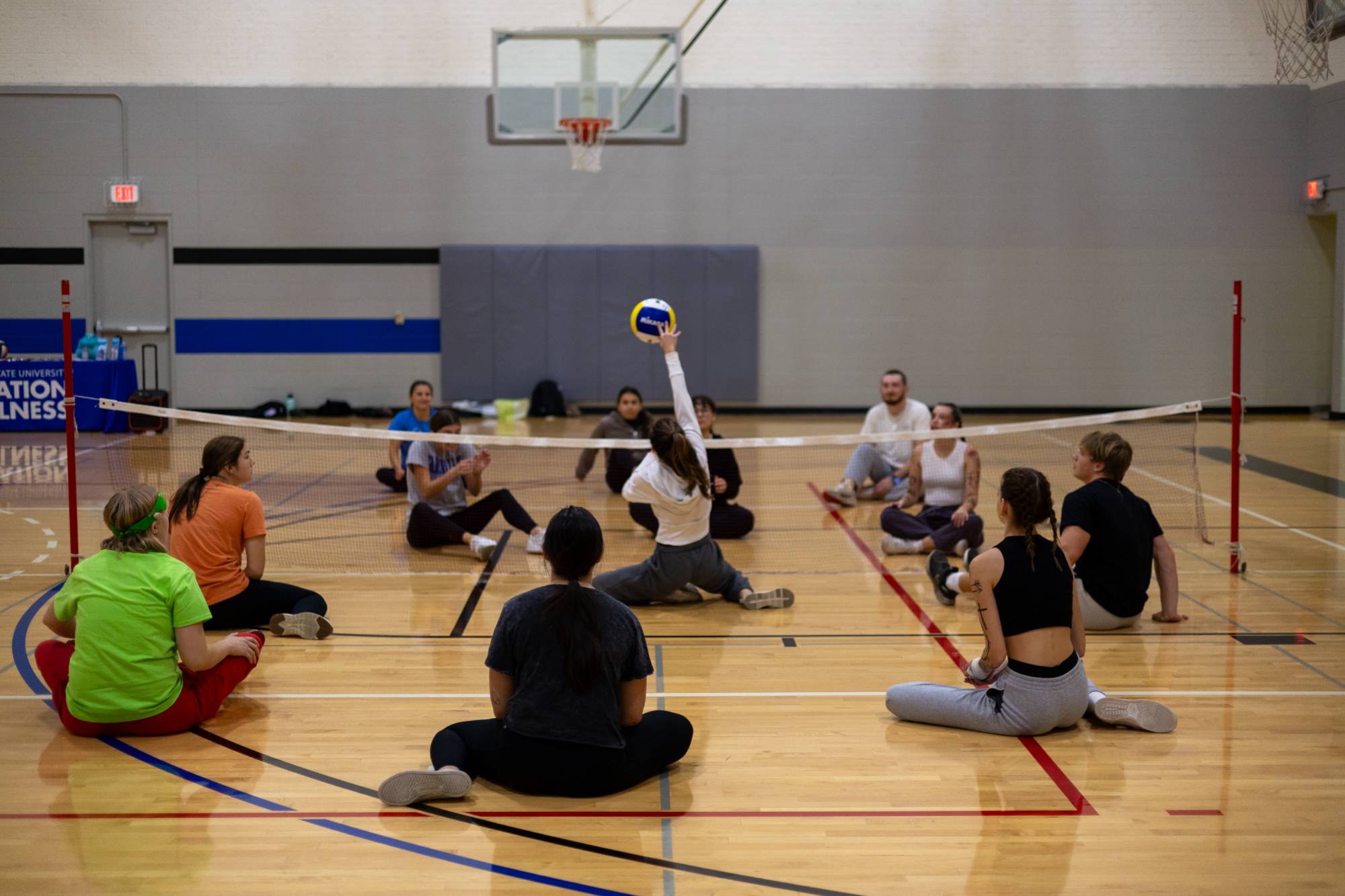 Students playing seated volleyball at an adaptive intramural sports event